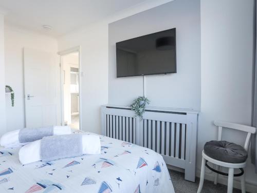 a bedroom with a bed and a tv on the wall at Glasfryn in Holyhead