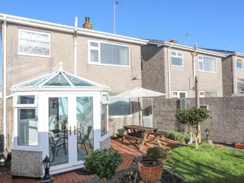 a white gazebo in the backyard of a building at Glasfryn in Holyhead