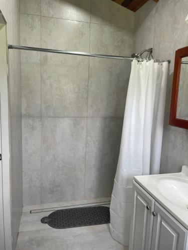 a shower with a shower curtain in a bathroom at Full Belizean Cabin in Spanish Lookout