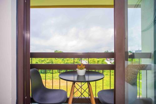d'une petite table et de deux chaises sur un balcon. dans l'établissement The Zen Den, Pine Suites Tagaytay, à Tagaytay