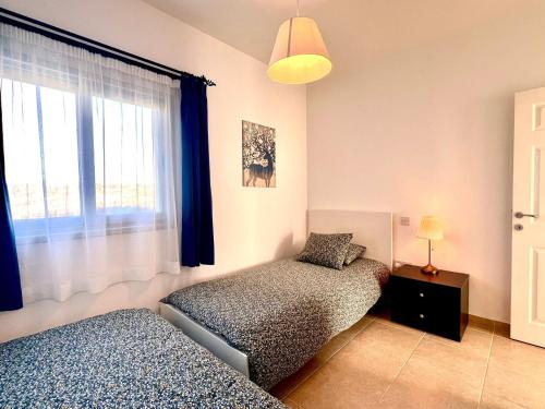 a bedroom with two beds and a window at Seafront holiday home surrounded by nature in Tatlisu, Northern Cyprus in Akanthou