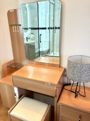 une coiffeuse avec un miroir et une chaise dans l'établissement Chambre Lucas Salle de bain Privative, à Paris