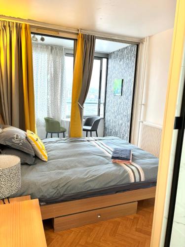 a bedroom with a bed with a large window at Chambre Lucas Salle de bain Privative in Paris