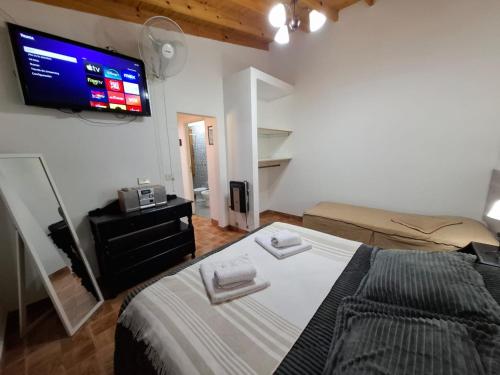 a bedroom with a bed and a tv on the wall at MarinaBella Habitación 5 in Rada Tilly