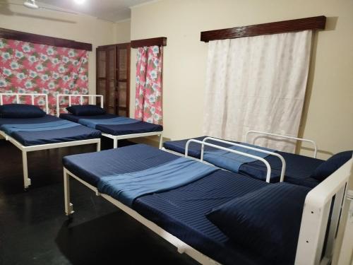 a room with three beds in it with a window at Holy Spirit Mission Camps in Mount Lavinia