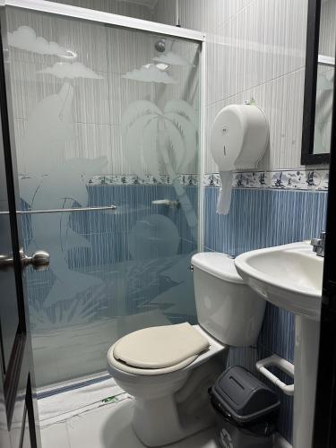 a bathroom with a shower and a toilet and a sink at Hotel Palmeras De Mariana in Bucaramanga