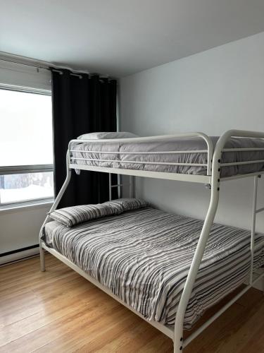 een stapelbed in een kamer met een raam bij 881 L'APPARTEMENT FAMILIAL "Central" in Québec