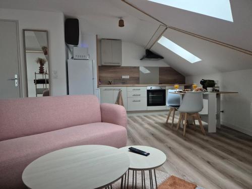 un salon avec un canapé rose et une table dans l'établissement La Canopée de Vichy - 4min Gare, à Vichy