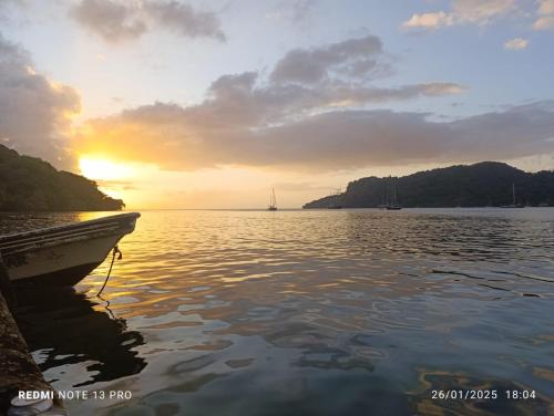 a boat on the water with a sunset in the background at Hostal Portobelo in Portobelo