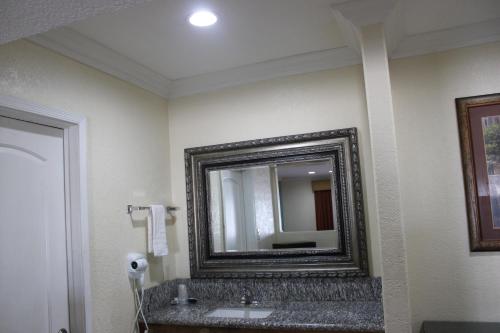 a bathroom with a mirror and a sink at El Rancho Motel in Yuma