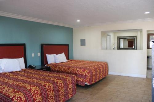 a hotel room with two beds and a mirror at El Rancho Motel in Yuma