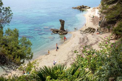 un groupe de personnes sur une plage près de l'eau dans l'établissement Le Mourillon Grand appartement proche des plages, à Toulon