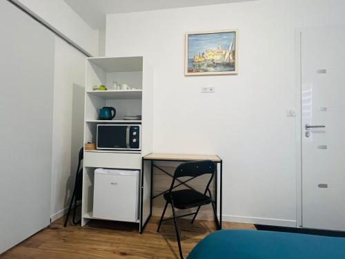 une petite cuisine avec une table et un micro-ondes dans l'établissement logement neuf avec accès indépendant, à Poitiers