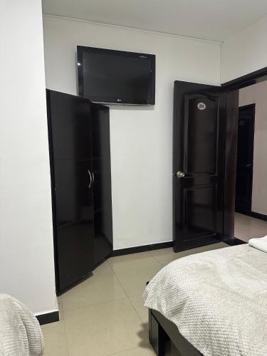 a bedroom with a bed and a flat screen tv at Hotel Palmeras De Mariana in Bucaramanga