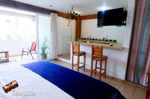 a bedroom with a bed and a table and chairs at La Pirámide del Tepozteco in Tepoztlán