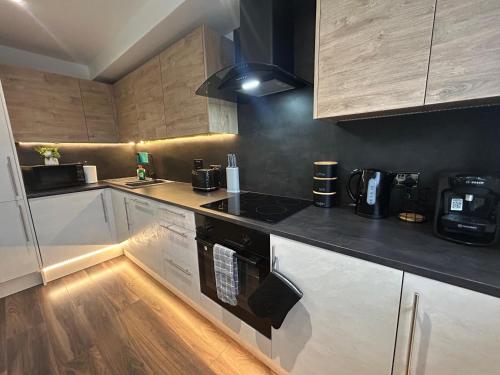 a kitchen with white cabinets and a stove top oven at NEW! Amazing Studio Apartment Sleeps 3 Hull Central in Hull