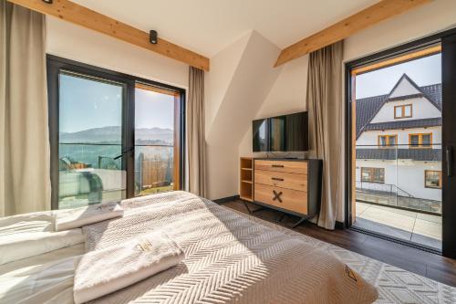 a bedroom with a bed and a large window at HARENDA APART Ski&Spa in Zakopane