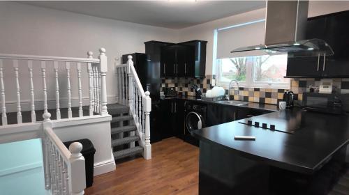 a kitchen with black cabinets and a black counter top at Roman apartment in Skegness
