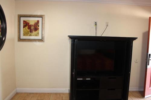 a black entertainment center with a television in a room at El Rancho Motel in Yuma