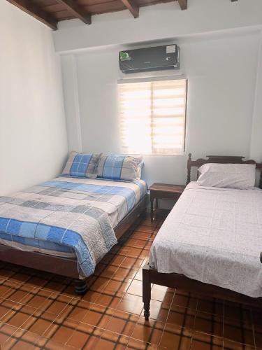 a bedroom with two beds and a window in it at Punta Blanca Beach House Amazing for Families in Punta Blanca