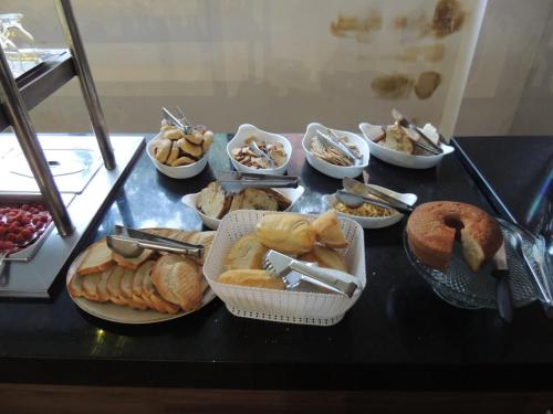 een tafel met veel verschillende soorten voedsel bij Hotel Colibri Viçosa - Próximo a UFV in Viçosa