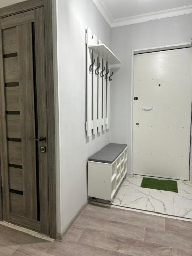 a white room with a door with a bench next to it at Luxe-apartments 2х in Taraz