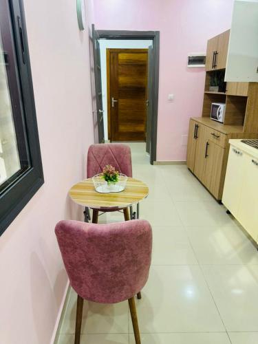 a small table and two chairs in a kitchen at Marie in Grand-Bassam