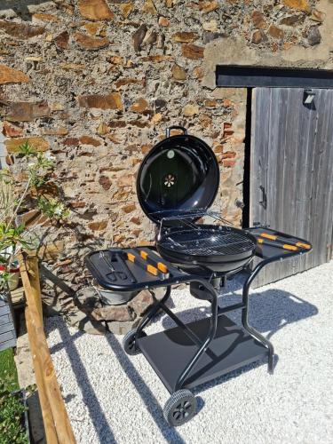 - un barbecue installé devant un mur en pierre dans l'établissement Villa Familiale near beaches, à Les Sables-dʼOlonne