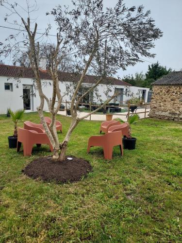 un arbre avec bancs rouges dans une cour dans l'établissement Villa Familiale near beaches, à Les Sables-dʼOlonne