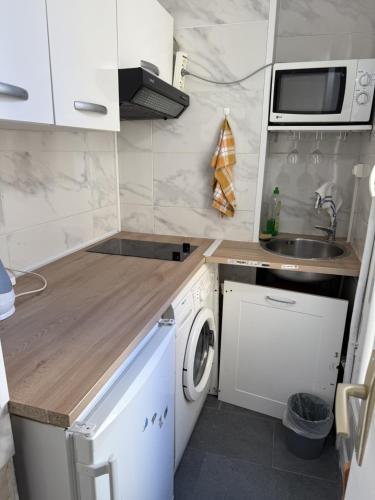 une petite cuisine avec une machine à laver et un évier dans l'établissement Studio Paris 15e D - Tour Eiffel Roland Garros, à Paris