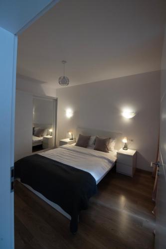 a bedroom with a large bed and two night stands at Central Residence in Baia Mare