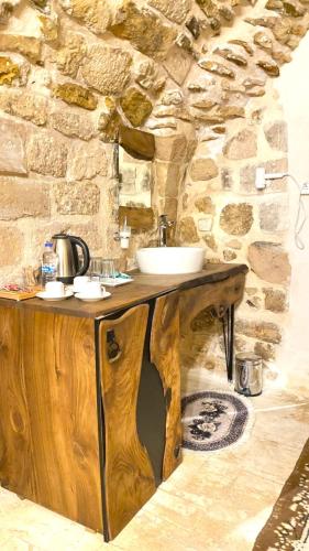 ein Badezimmer mit einem Holzwaschbecken und einer Steinwand in der Unterkunft Sultan Konağı Hotel - Heritage Stay in Mardin