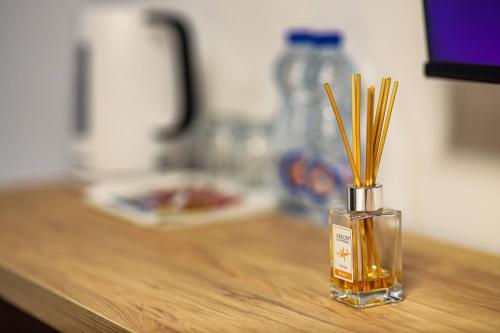 a vase with sticks in it sitting on a table at Hotel Privé in Peje