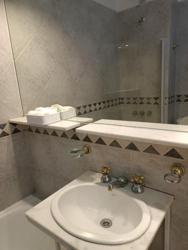 a bathroom with a white sink and a mirror at Nice apartment in good location in Buenos Aires
