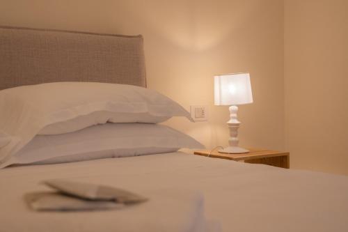 a bed with a white pillow and a lamp at Moliké country house in Giulianova