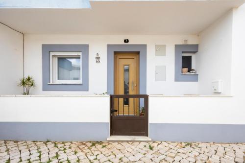 a front door of a white house with a brown door at CASA Castelejo in Vila do Bispo