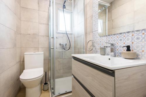 a bathroom with a toilet and a sink and a shower at CASA Castelejo in Vila do Bispo