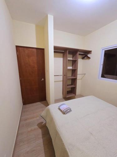 a bedroom with a bed and a wooden door at Apartamentos Mundo Maya in Flores