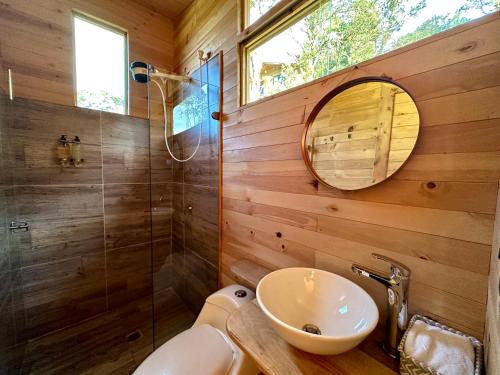 a bathroom with a toilet and a sink and a mirror at Neusa Hills Glamping in Tausa Viejo