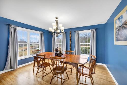 a dining room with blue walls and a wooden table and chairs at Serene 7BR Haven by the Lake home in Sullivan