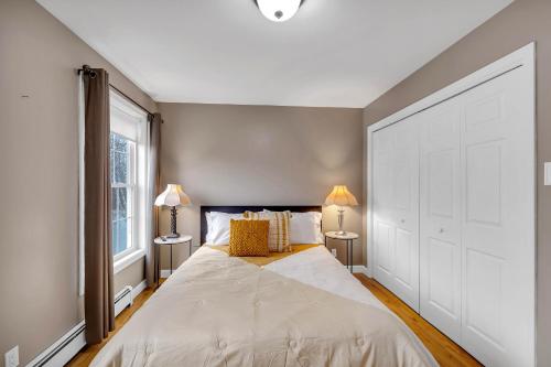 a bedroom with a large bed and two lamps at Serene 7BR Haven by the Lake home in Sullivan