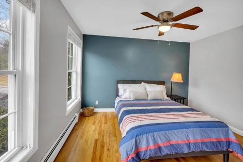 a blue bedroom with a bed and a ceiling fan at Serene 7BR Haven by the Lake home in Sullivan