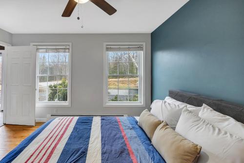 a bedroom with a bed and two windows at Serene 7BR Haven by the Lake home in Sullivan