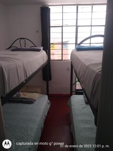 a room with two beds and a window at Hospedaje snack bar titanic in Ica