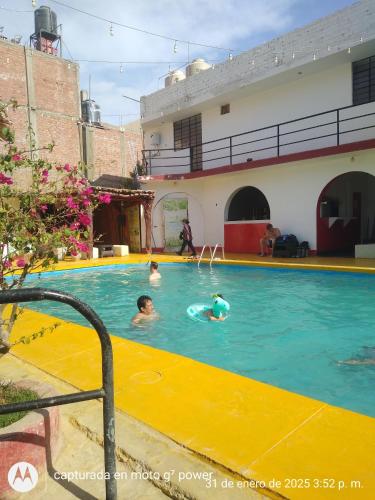 a group of people swimming in a swimming pool at Hospedaje snack bar titanic in Ica