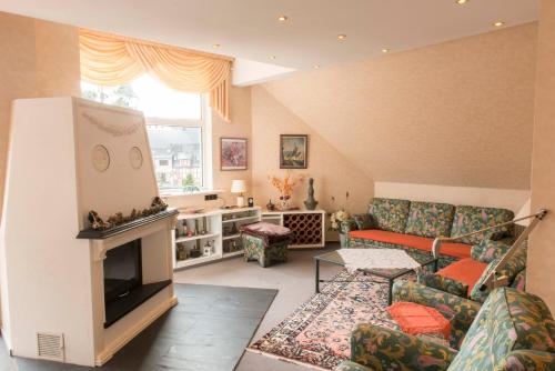 een woonkamer met een bank en een open haard bij Ferienwohnung Burg Eltz in Treis-Karden