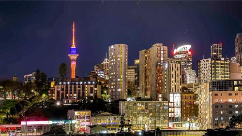 a city skyline at night with a tall tower at Parnell Haven 2BRM Apartment with Deck, Parking & City Views in Auckland