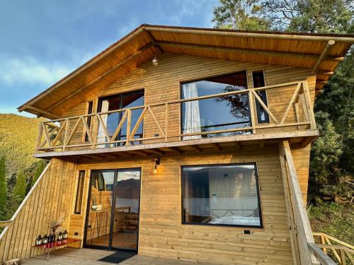 a house with a deck on top of it at Neusa Hills Glamping in Tausa Viejo
