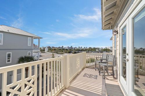 a balcony with a table and chairs and a view of the ocean at Seeking Sunsets 30A in Rosemary Beach