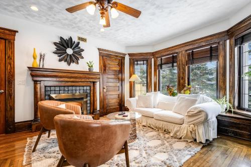a living room with a couch and chairs and a fireplace at The Miracle Room at Dream BNB Estate Inn in Leamington